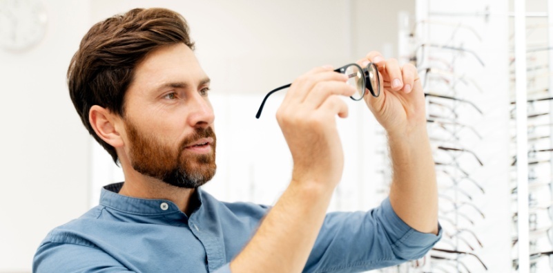 Man examining glasses in an optician