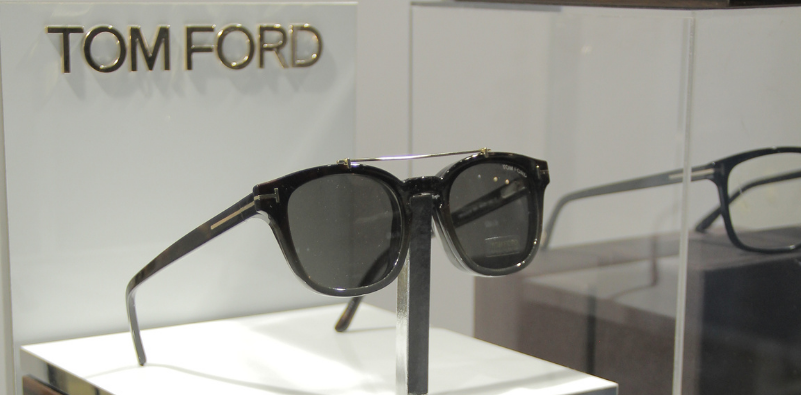 A pair of signature black Tom Ford sunglasses on a display stand at the opticians