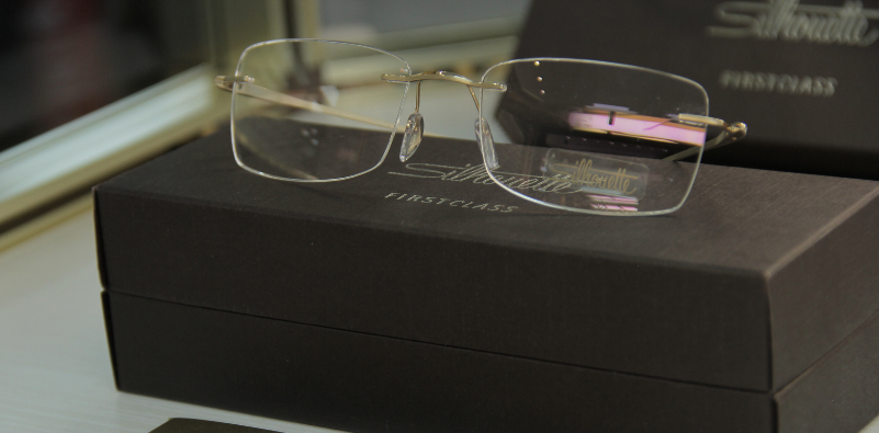 A pair of rimless Silhouette glasses on top of a Silhouette branded box