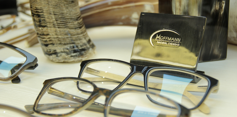 Two pairs of Hoffmann Eyewear on display at Optix with branding and a buffalo horn in the background.]