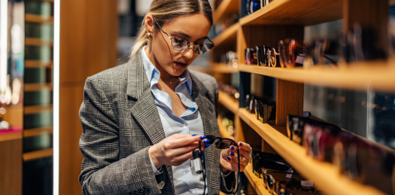 A stylish, professional young woman looking at glasses at the opticians.