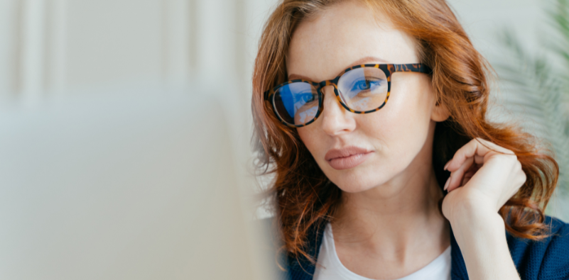 Woman wearing glasses looking at a laptop screen